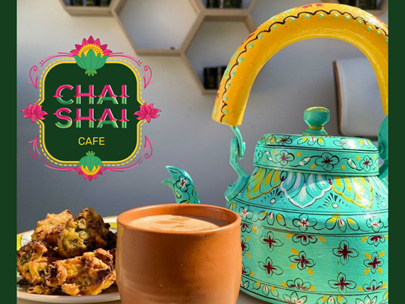 Teapot, tea cup and cake with 'Chai Shai Cafe text'.