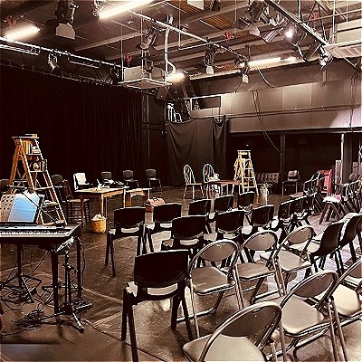 Large room with chairs arranged in the round and lots of aircon and lighting overhead