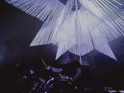 Simona Castricum playing electronic drums under a star shaped lighting installation
