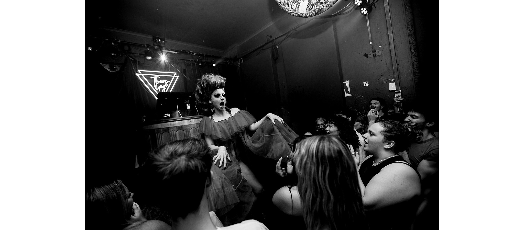 Black and white photo of a performer surrounded by an enthusiastic crowd