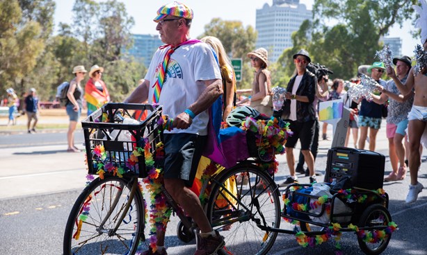 Colourfully dress man on a bicycle at Midsumma Pride March