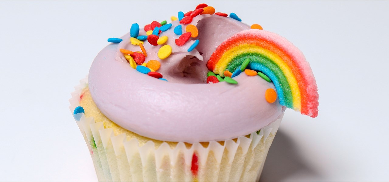 Cupcake with icing, rainbow sprinkles and rainbow candy deocration
