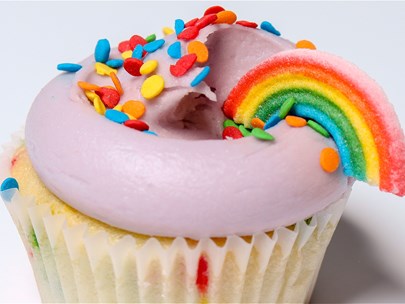 Cupcake with icing, rainbow sprinkles and rainbow candy deocration