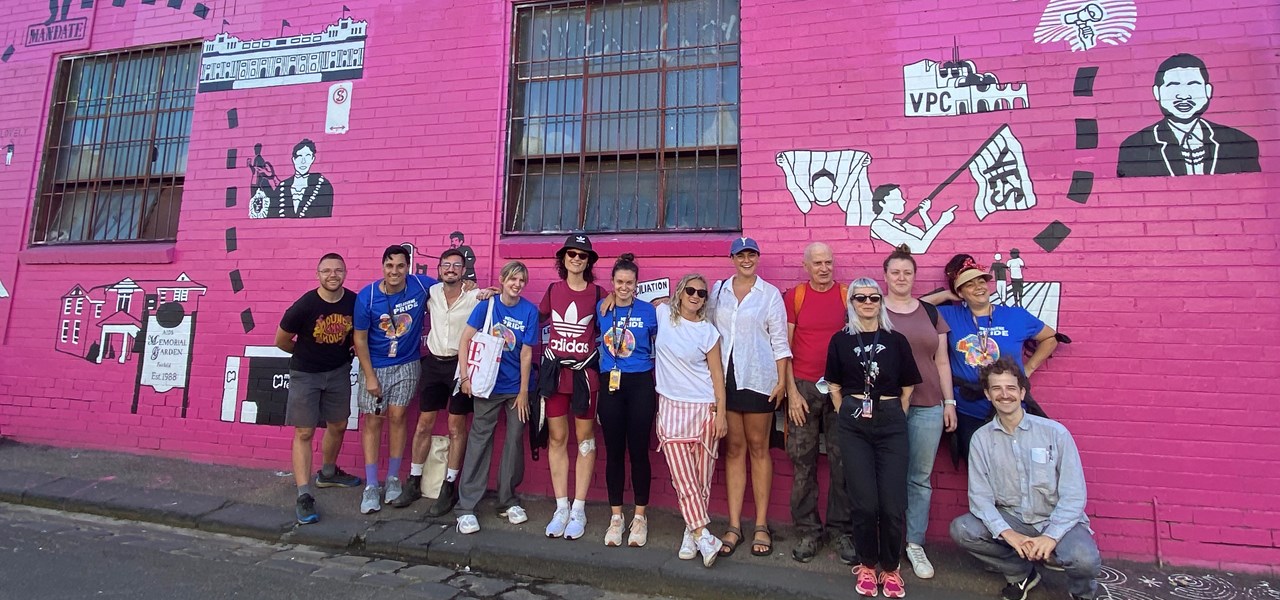 Midsumma Staff standing in front of a Melbourne Pride (2022) mural