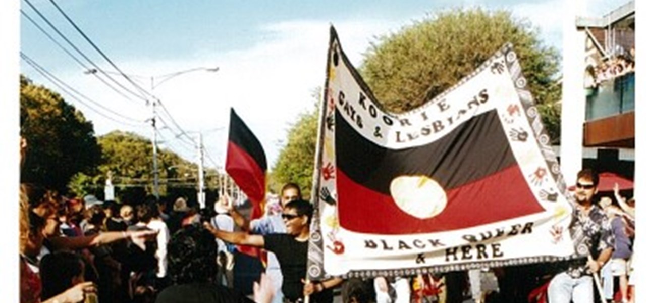 Pride March 2000 image: marchers holding a large Koorie banner