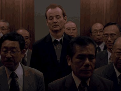 People standing in an elevator - most of Japanese appearance, with a famous American actor towering above them in the middle