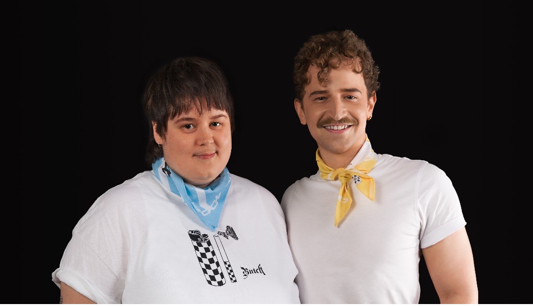 Two young people standing together posing for the camera, dressed in white t-shirts and coloured neck bandanas