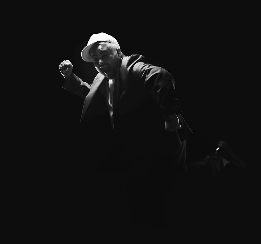 Dark black and white photo of Mo'Ju moving against a very dark background