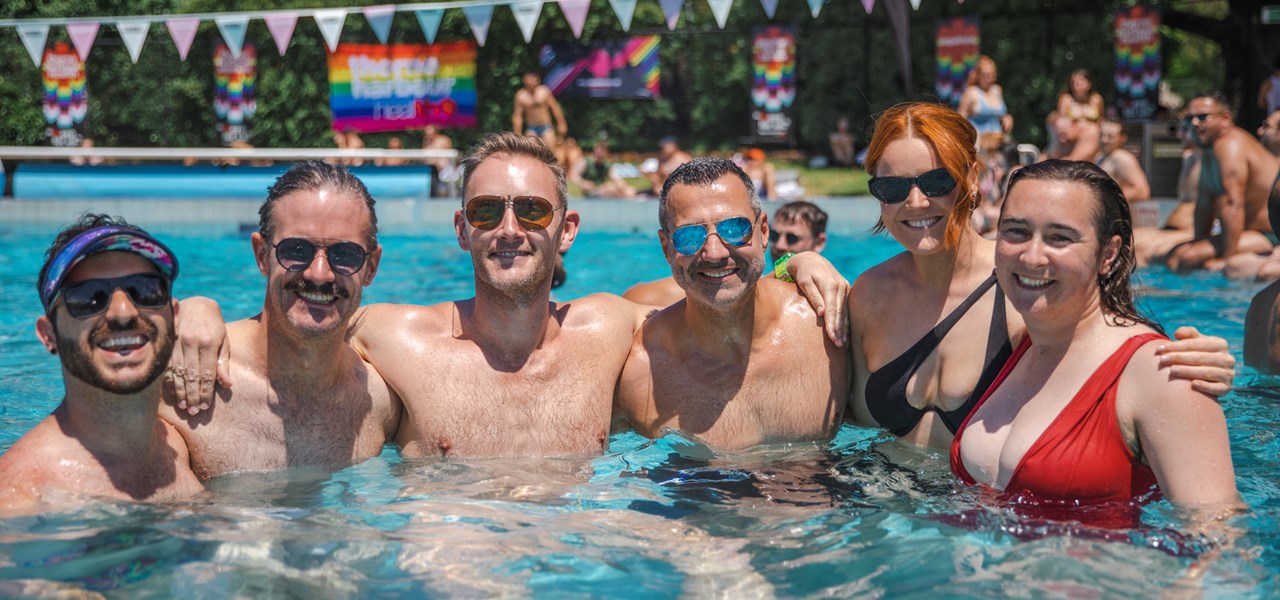 Group photo of people in a pool hugging