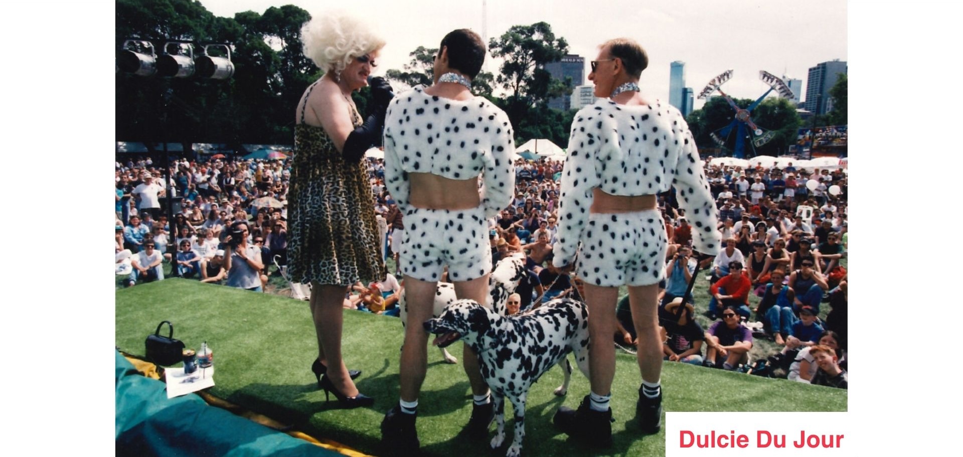 Dulcie Du Jour hosting the Dog Show at Carnival with two dog owners dressed like their dalmatian dog