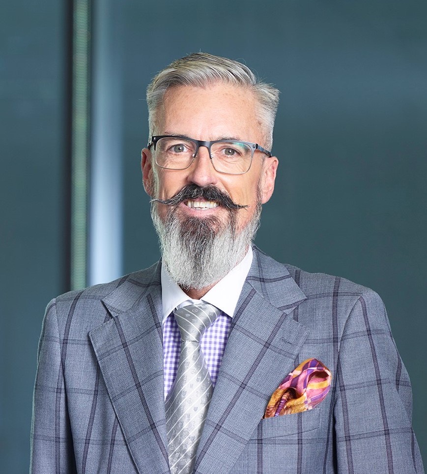Jason posing in a grey chequered suit with a grey silk tie, handkerchief in the suit pocket... very stylish