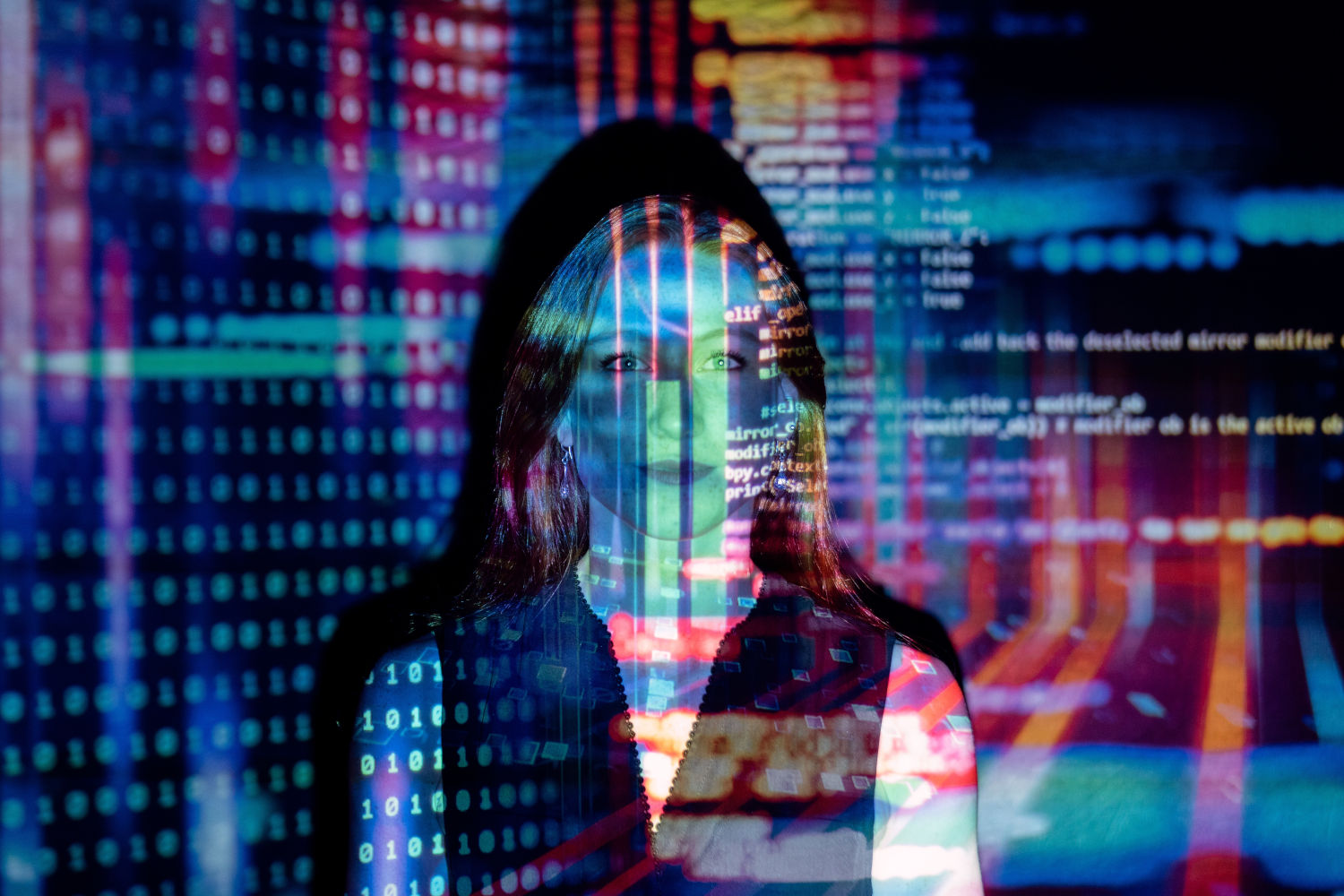 Young woman looking at the camera, partially obliterated by reflections of high rise buildings and text