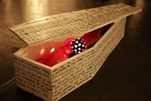 Coffin with lid partly open and games illuminated inside it