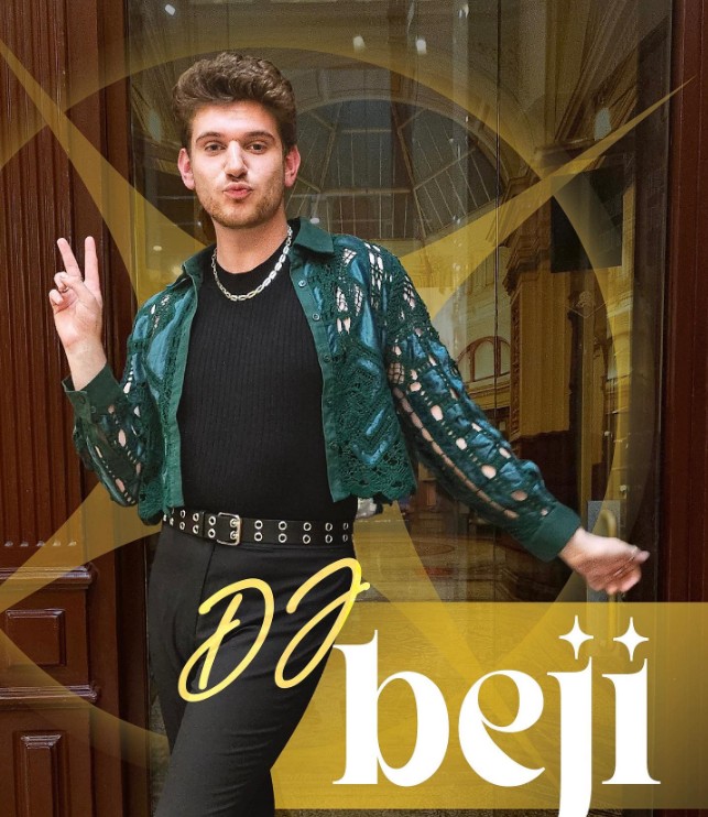 DJ Beji dressed elegantly and making the peace sign