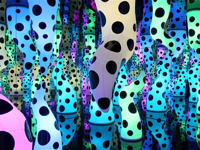 An abstract forest of multi-coloured curved upright shapes each sparsely covered in black dots