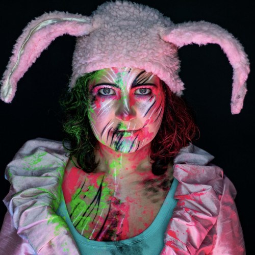 Jessie with lots of body paint wearing a pink floppy rabbit-ears hat