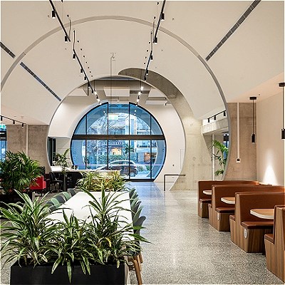 Forum space in the Pride Centre looking towards Fitzroy Street, showing a large central table and bench seats with tables on the side