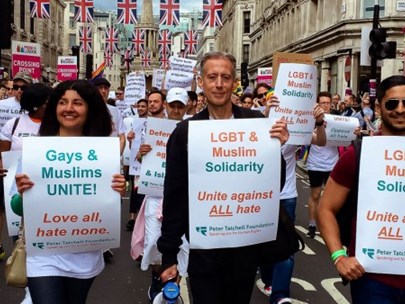 A street protest with lots of people holding signs about gays and muslims against hate