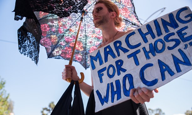 Person at Midsumma Pride March with banner: "Marching for those who can't"
