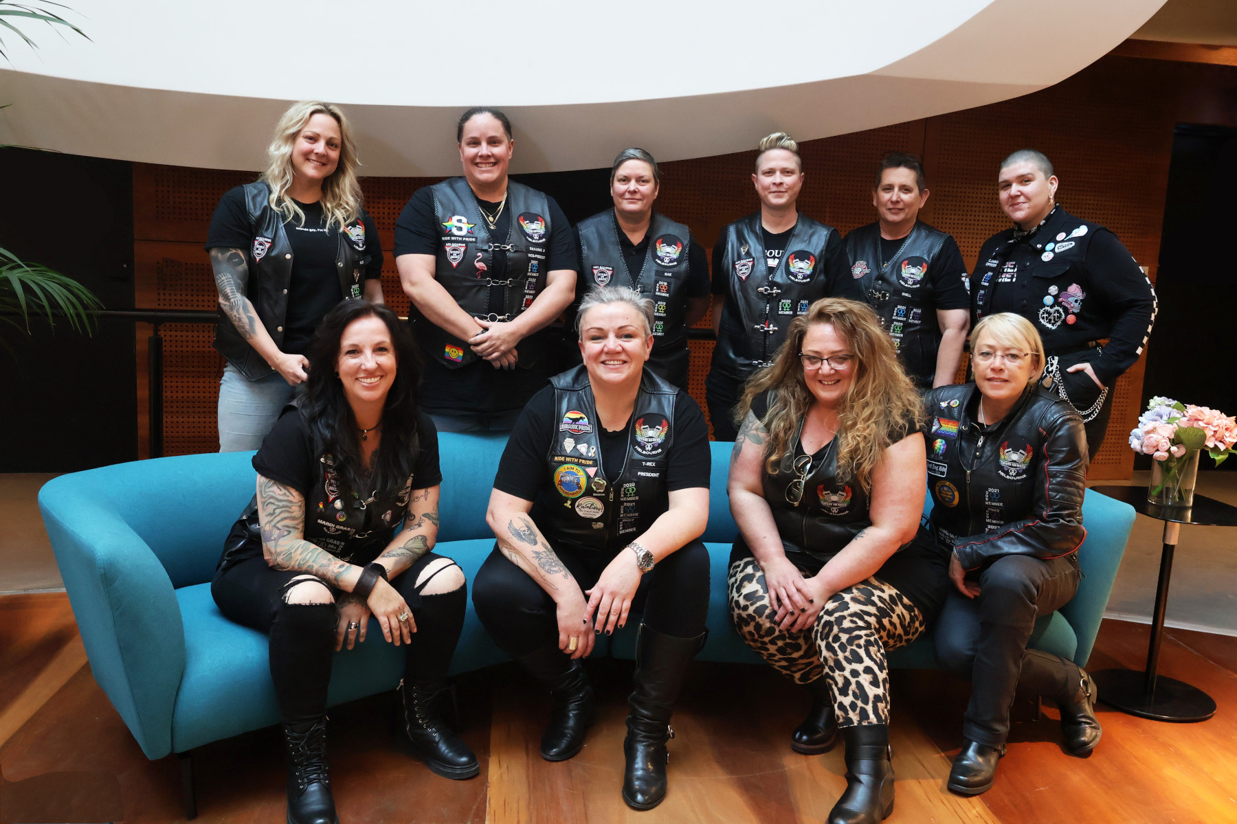 A group photo of 10 Dykes on Bikes Melbourne members wearing their biker vests.