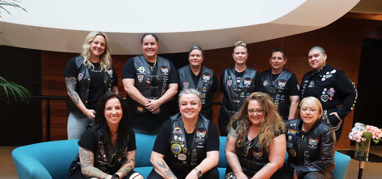 A group photo of 10 Dykes on Bikes Melbourne members wearing their biker vests.