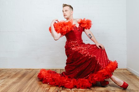 Thomas Jaspers in red shoes and a flowing red gown