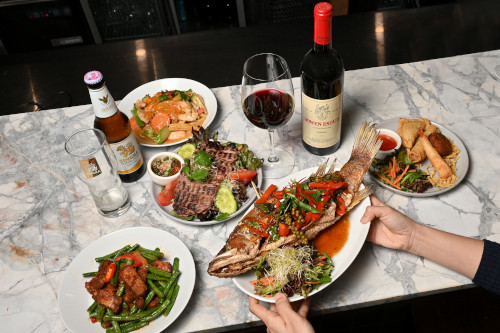 A selection of dishes on a marble bench top with a fish dish as the focal point