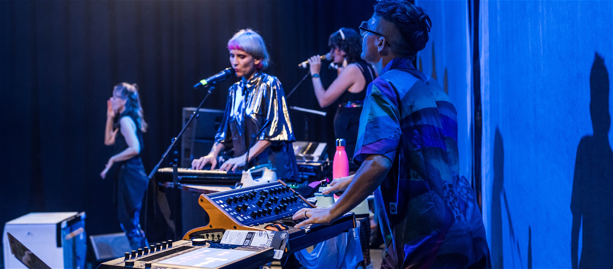 A group of performers singing and playing keyboards