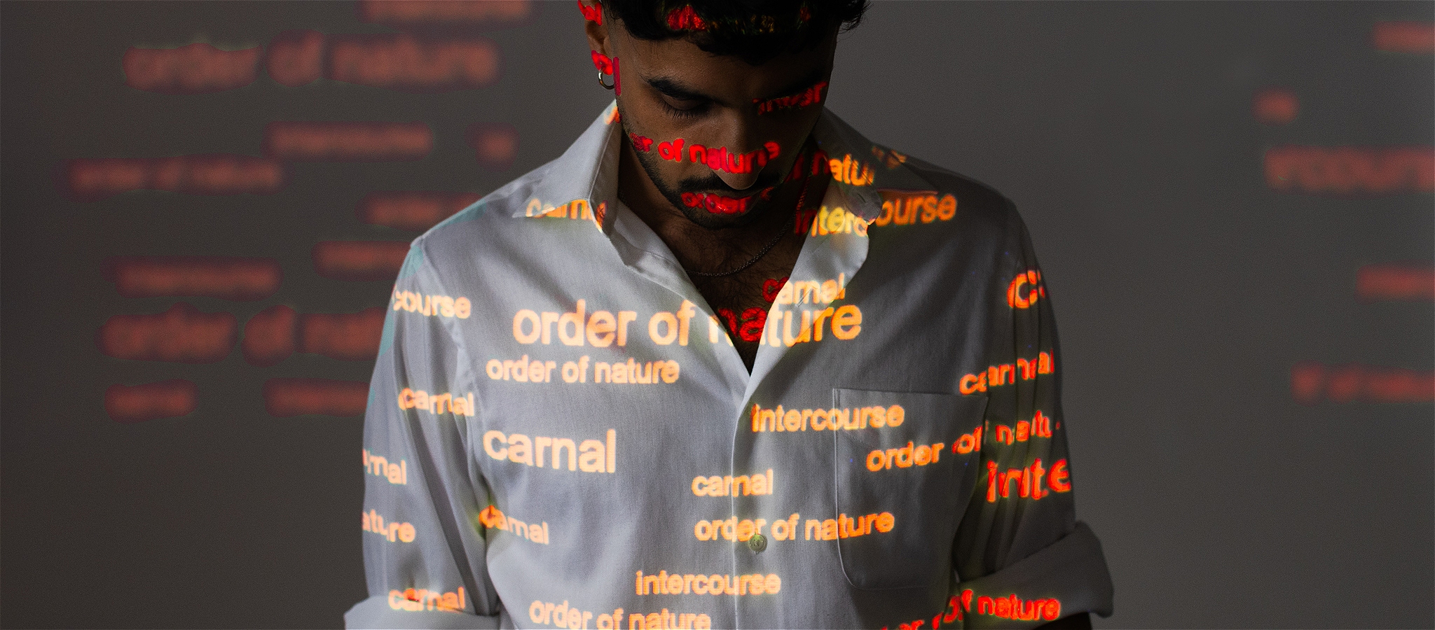 An image of the artist with words projected onto their body.