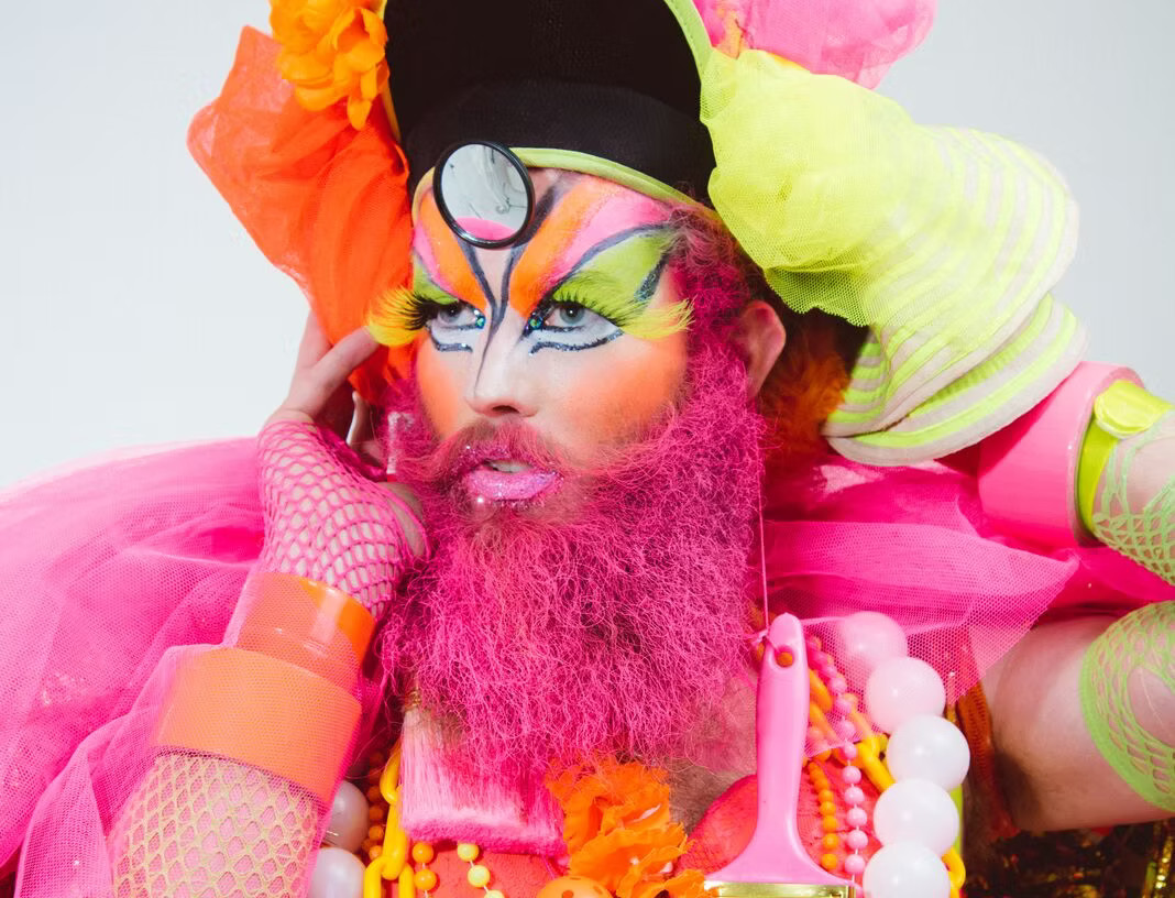 Dandrogyny very colourfully dressed with face painting and pink beard