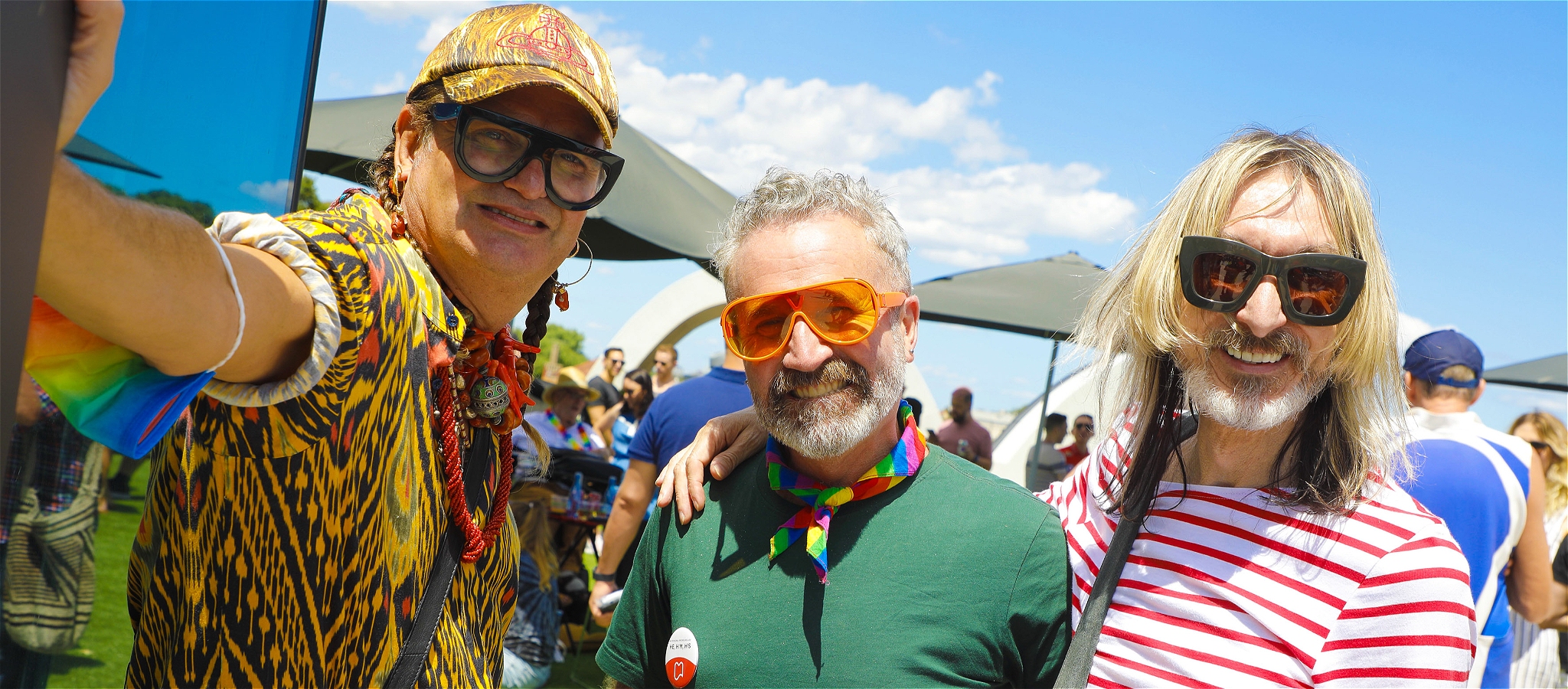 A photo of a three fabulous people wearing sunglasses and smiling into the camera