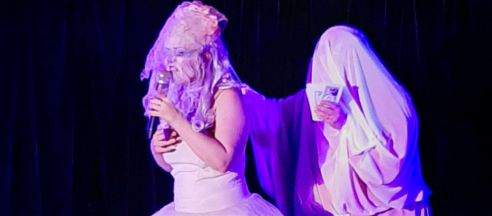 Cloutie Will singing with mic in ballgown & veil with Madam Nightingale dancing in ghost costume throwing money
