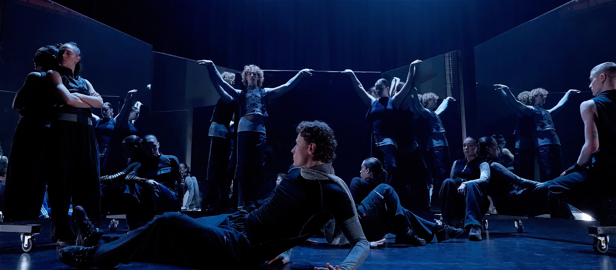 Dancers leaning/posed across large mirrors