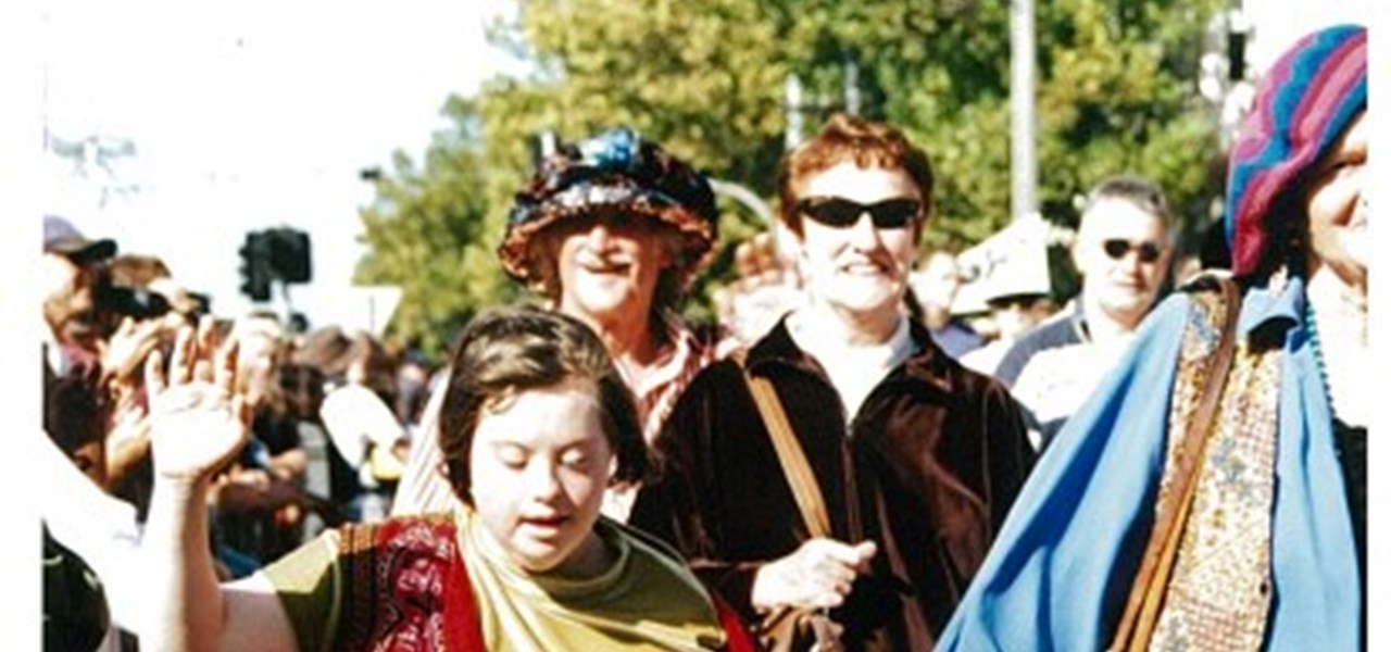Pride March 2000 image: colourfully dressed people walking and waving