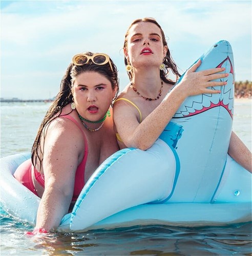 Two women in bathing suits on a shark-shaped lilo