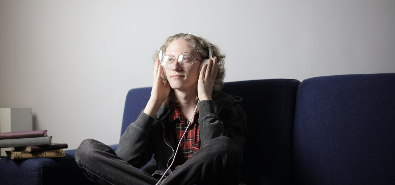 Person sitting on couch - listening to audio through their headphones