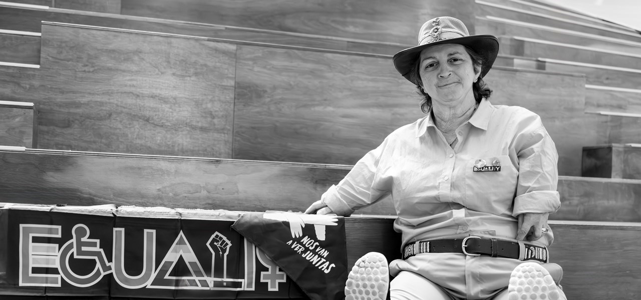 Black and white photo of Margherita Coppolino sitting on the stairs of the Victorian Pride Centre