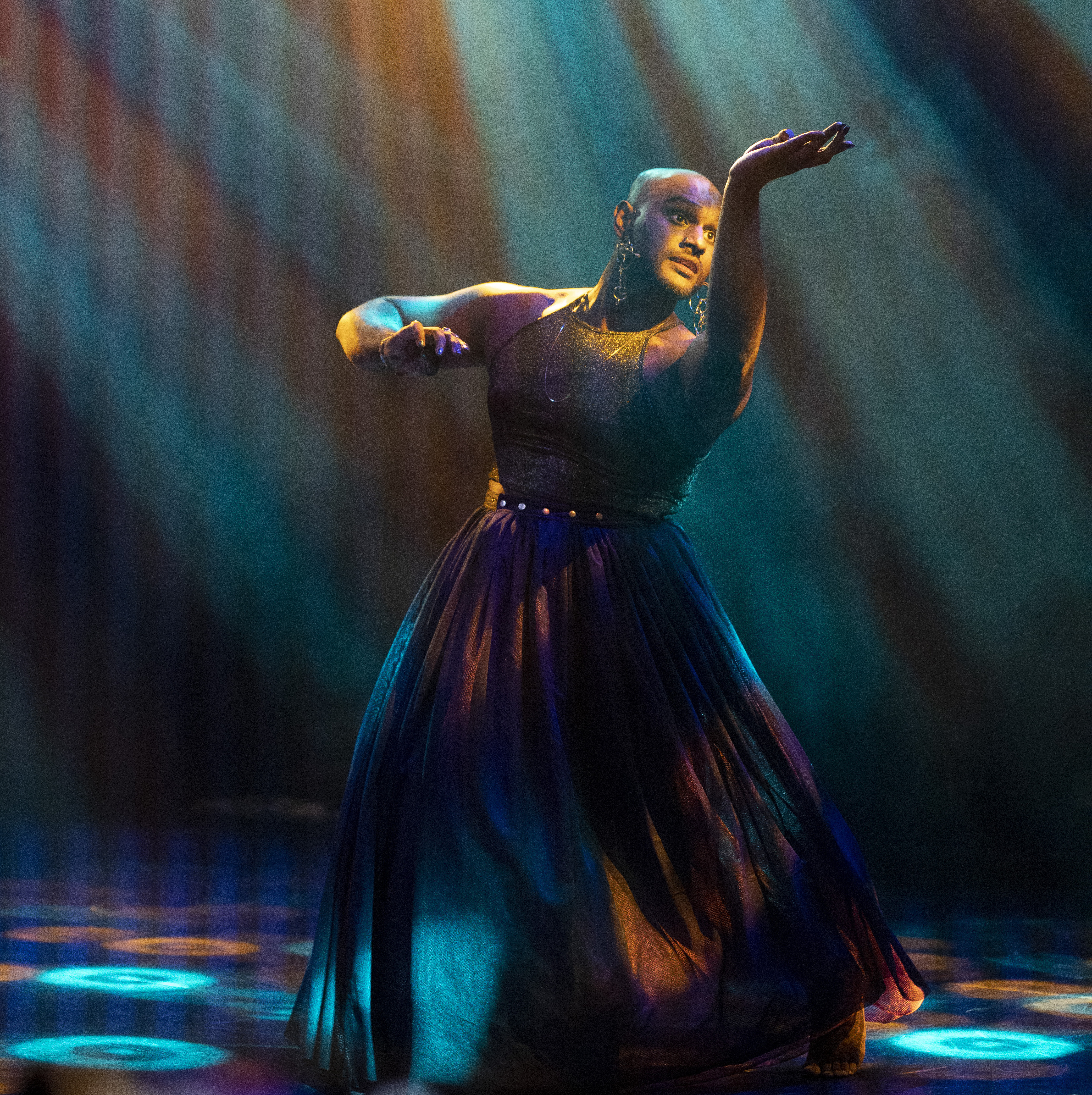 Naavikaran striking a classic Indian dance pose with arms outstretched.