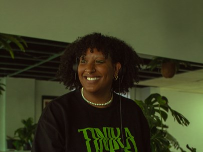 Tinika at the decks, smiling, wearing a Tinika t-shirt