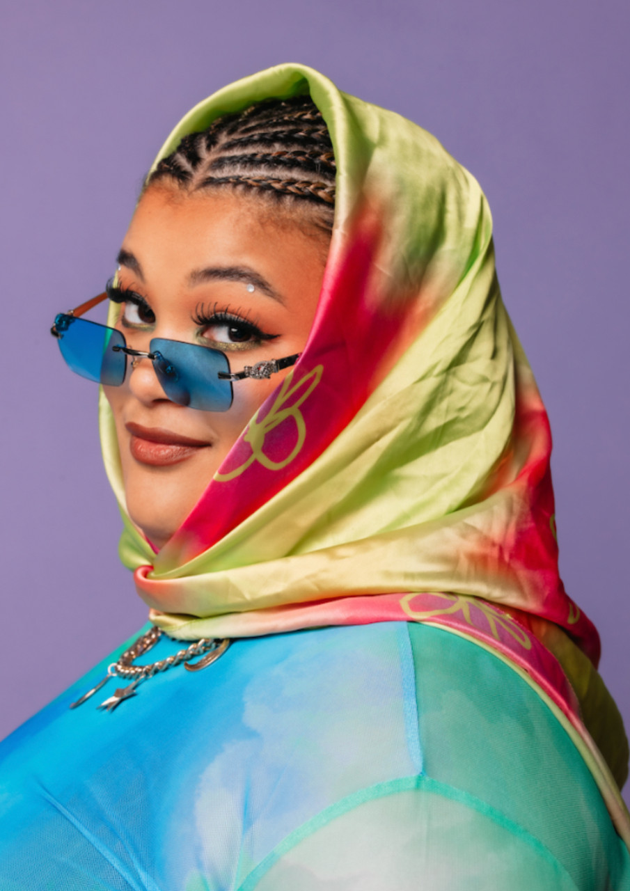 Milo Hartill dressed in a discrete rainbow scarf and dark glasses looking a little sexy