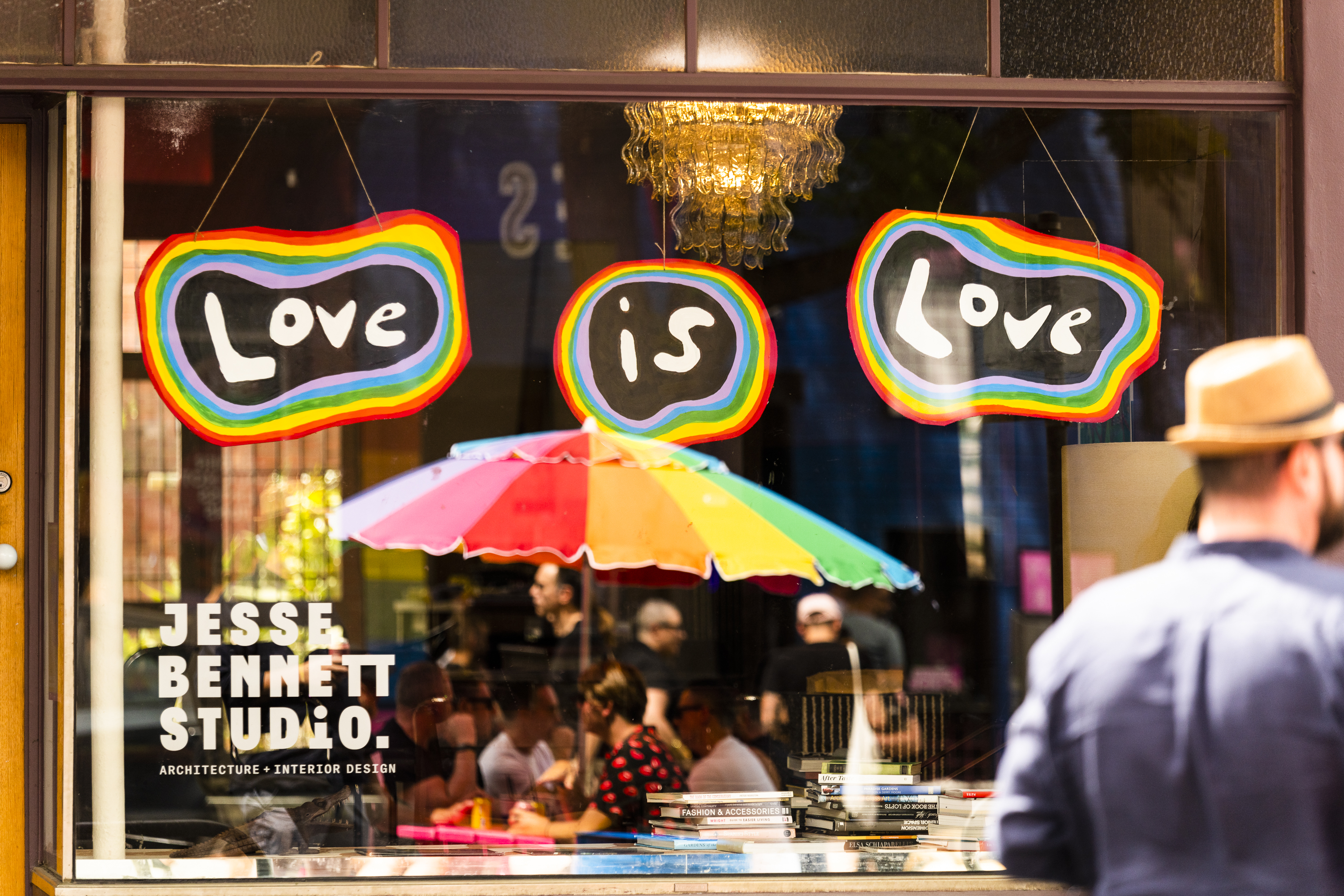 Photo of a person looking into the window of the Jesse Bennett Studio premises, which is gayly decorated