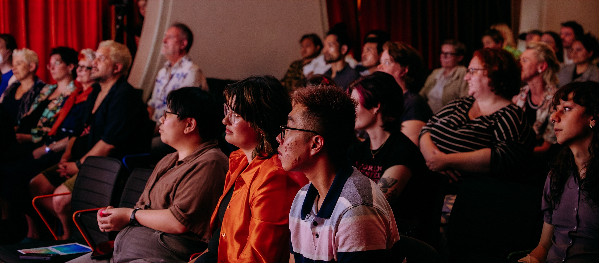 A photo of people seated in the auditorium looking towards the stage