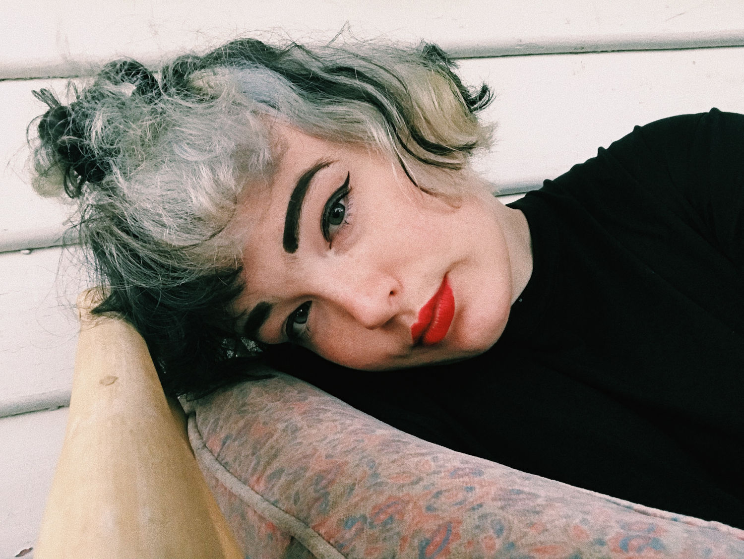 Headshot of Ebony lying sideways, head resting on a chair