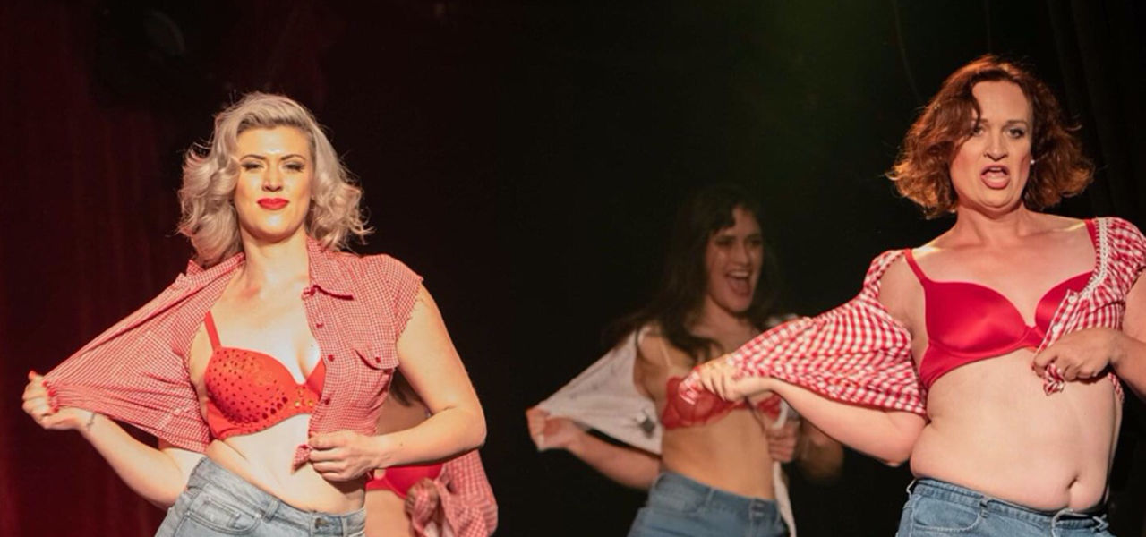 Three women wearing red silk bras and red & white checked shirts, opening the shirts