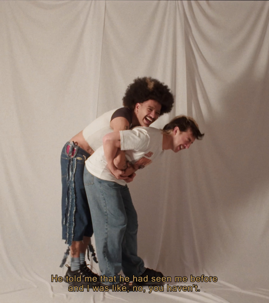 One person holding another with their arms wrapped around them. Both are laughing strongly.