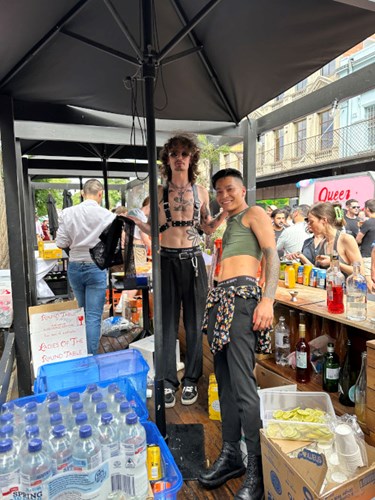 Two scantily led people in the street bar with Smith St crowds in the background