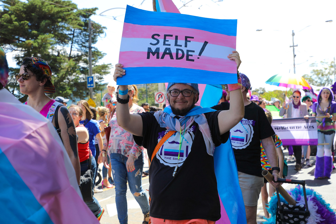 Crowd at Midsumma Pride March - the central person is holding a banner stating 'Self Made!'
