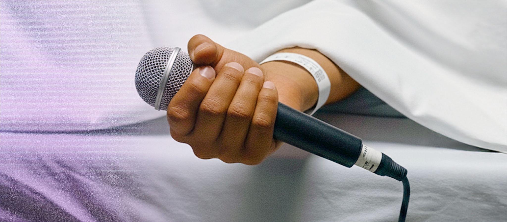 Hand holding a microphone with the text saying the title of the show