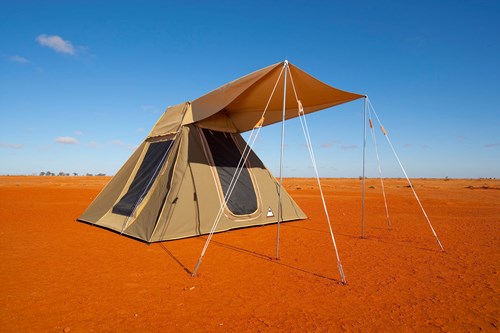 Tent pitched in an outback red-soil setting with blue sky