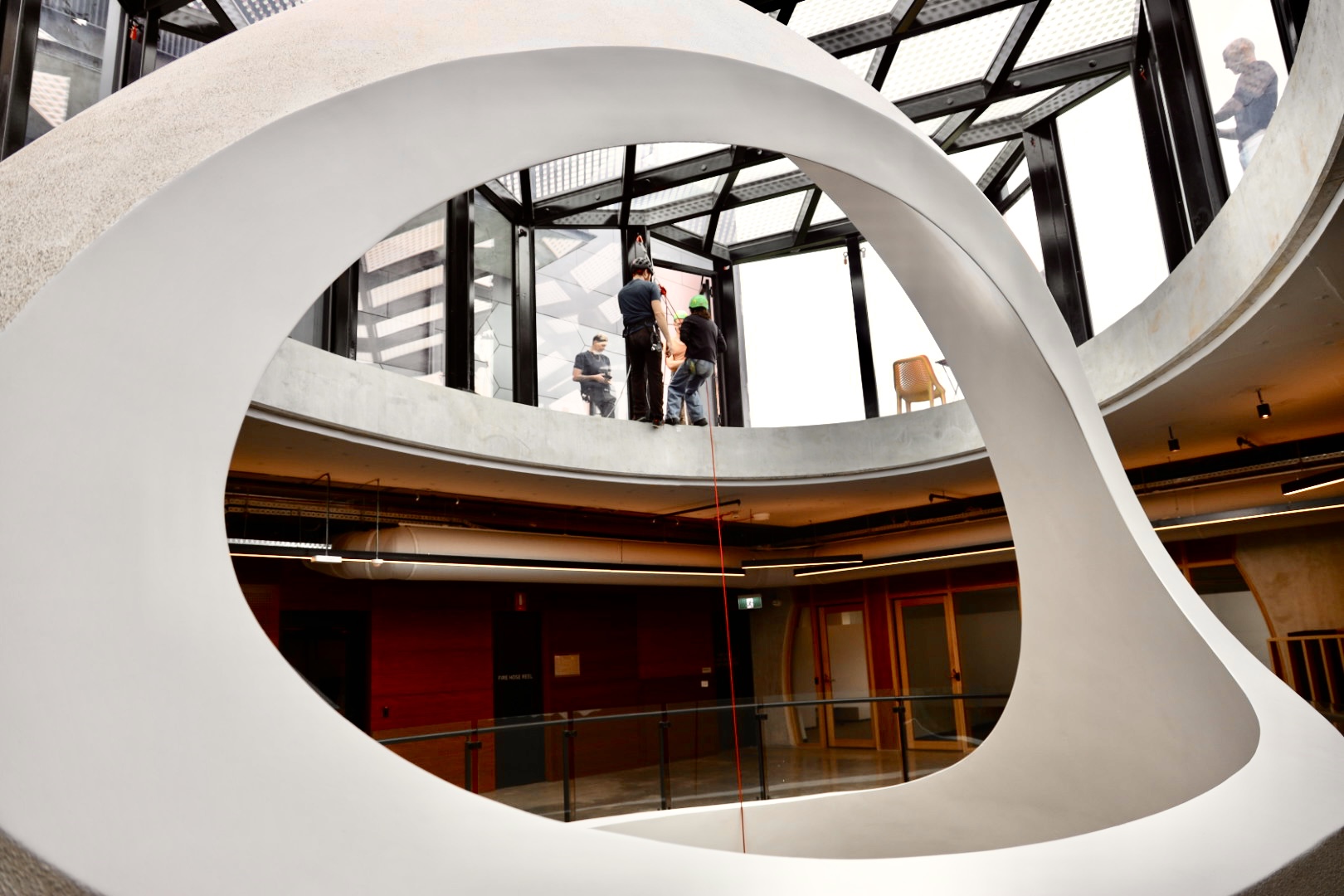A panorama of people preparing to abseil down the atrium of the Victorian Pride Centre